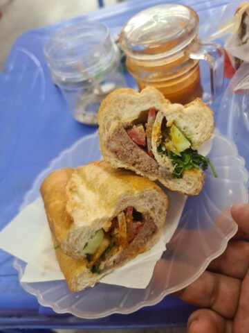 Một chiếc bánh mì pate truyền thống Hà Nội với vỏ vàng giòn, nhân đầy đặn, gợi nhớ ký ức tuổi thơ
