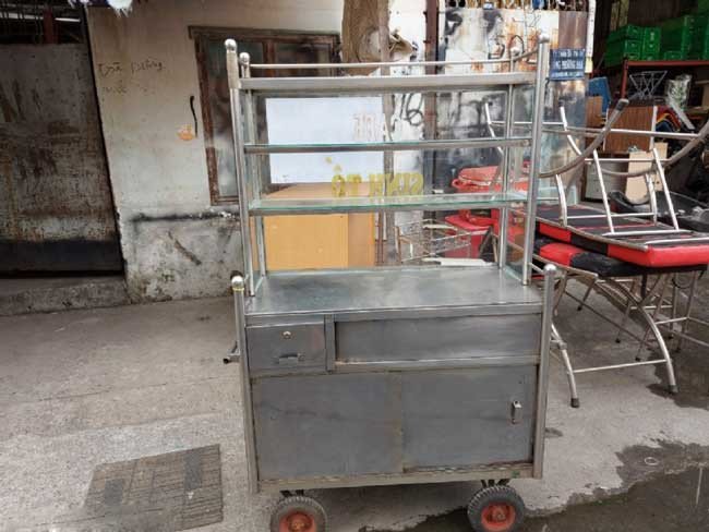 Một chiếc xe bánh mì chả cá thanh lý cũ kỹ, gỉ sét và kém thẩm mỹ