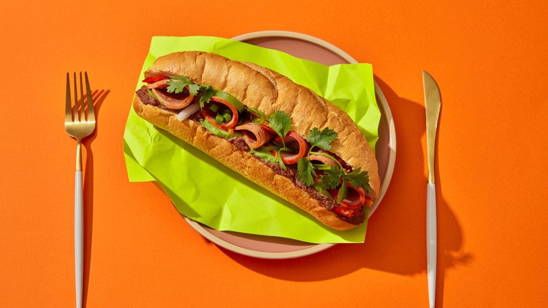 Một người đàn ông đang thưởng thức bữa sáng với bánh mì nguyên cám và hoa quả, tượng trưng cho lối sống lành mạnh