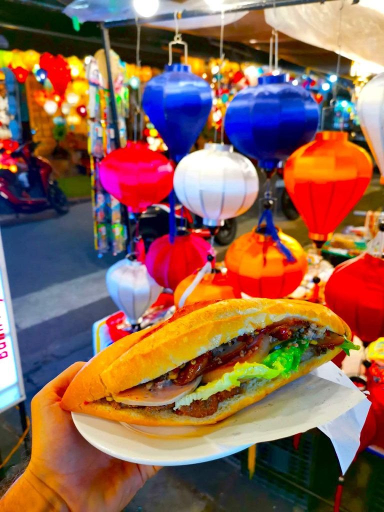 Một người đàn ông đứng trước quầy bánh mì Phượng ở Hội An, nơi Anthony Bourdain từng ghé thăm.