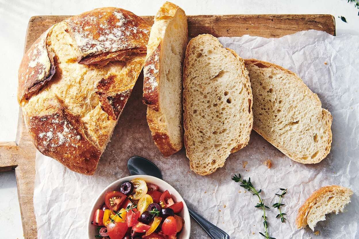 Một người đang cầm chiếc bánh mì baguette mới nướng
