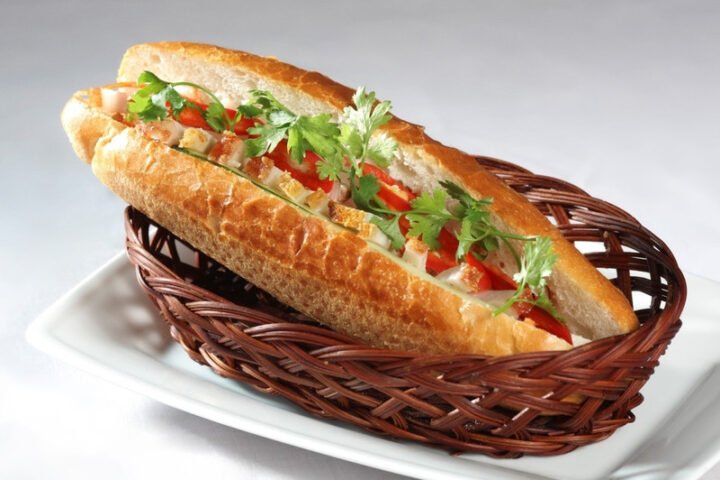 Một ổ bánh mì heo quay truyền thống Việt Nam với lớp da heo giòn rụm và nhân thịt đậm đà, cung cấp năng lượng và dưỡng chất.