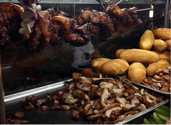 Một phần bánh mì với nhân xá xíu và phá lấu hấp dẫn tại một tiệm ăn