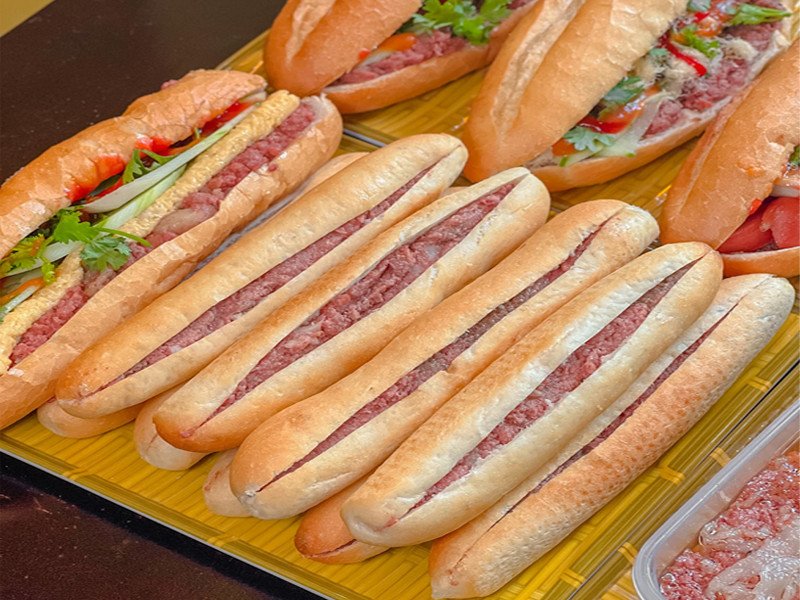 Một quầy tiệm bánh mì cay Ông Cuông đông đúc khách hàng.