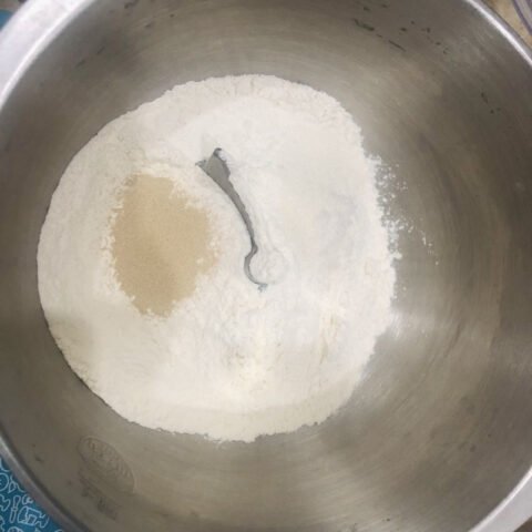 Người đàn ông đang cho nguyên liệu vào máy nhồi bột để làm bánh mì truyền thống