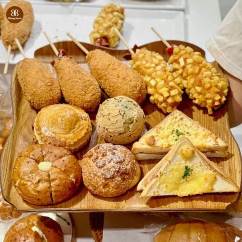 Người đang bọc bánh mì ngọt bằng giấy bạc để bảo quản