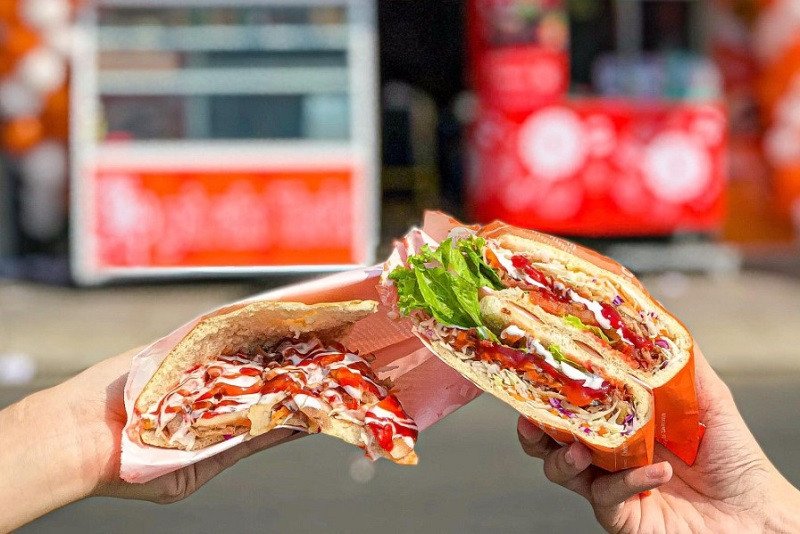 Người phụ nữ đang cắt giảm lượng thịt trong bánh mì cuộn để kiểm soát calo