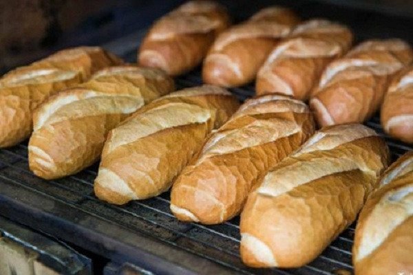 Người thợ bánh Saigonese Baguette kiểm tra chất lượng bánh sau khi nướng bánh mì với nhiệt độ và thời gian chuẩn xác.