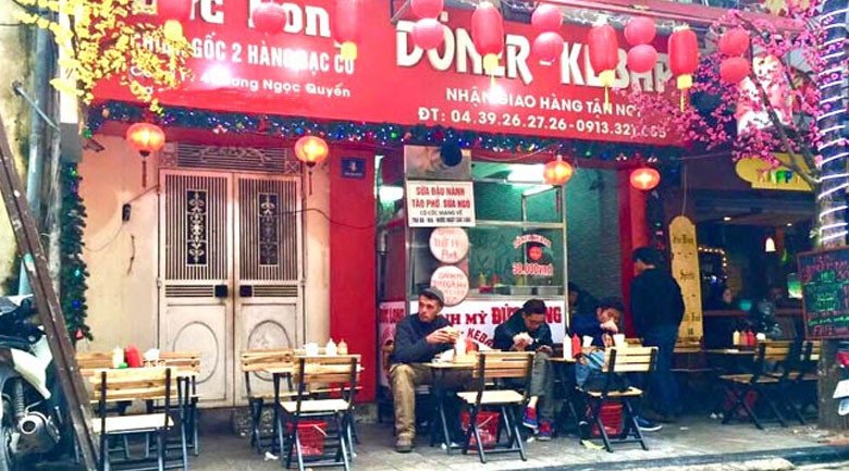 Người thợ đang cắt bánh mì, thể hiện sự tỉ mỉ trong từng công đoạn chế biến ẩm thực Hà Nội