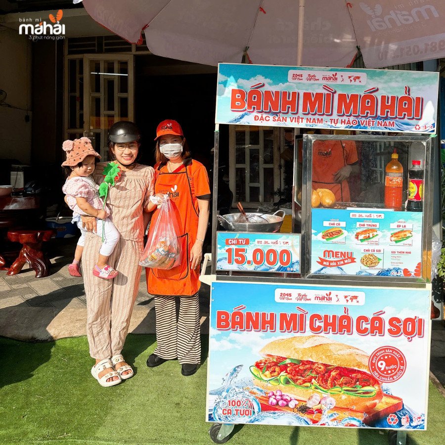 Nhân viên đang nhanh chóng chuẩn bị ổ bánh mì chả cá cho khách hàng