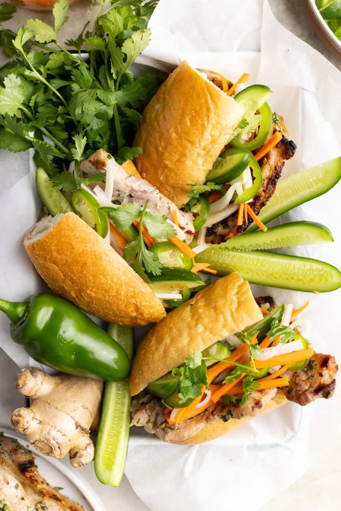Những ổ bánh mì thịt nướng hoàn chỉnh với dưa chuột, ớt jalapeño và rau mùi tươi