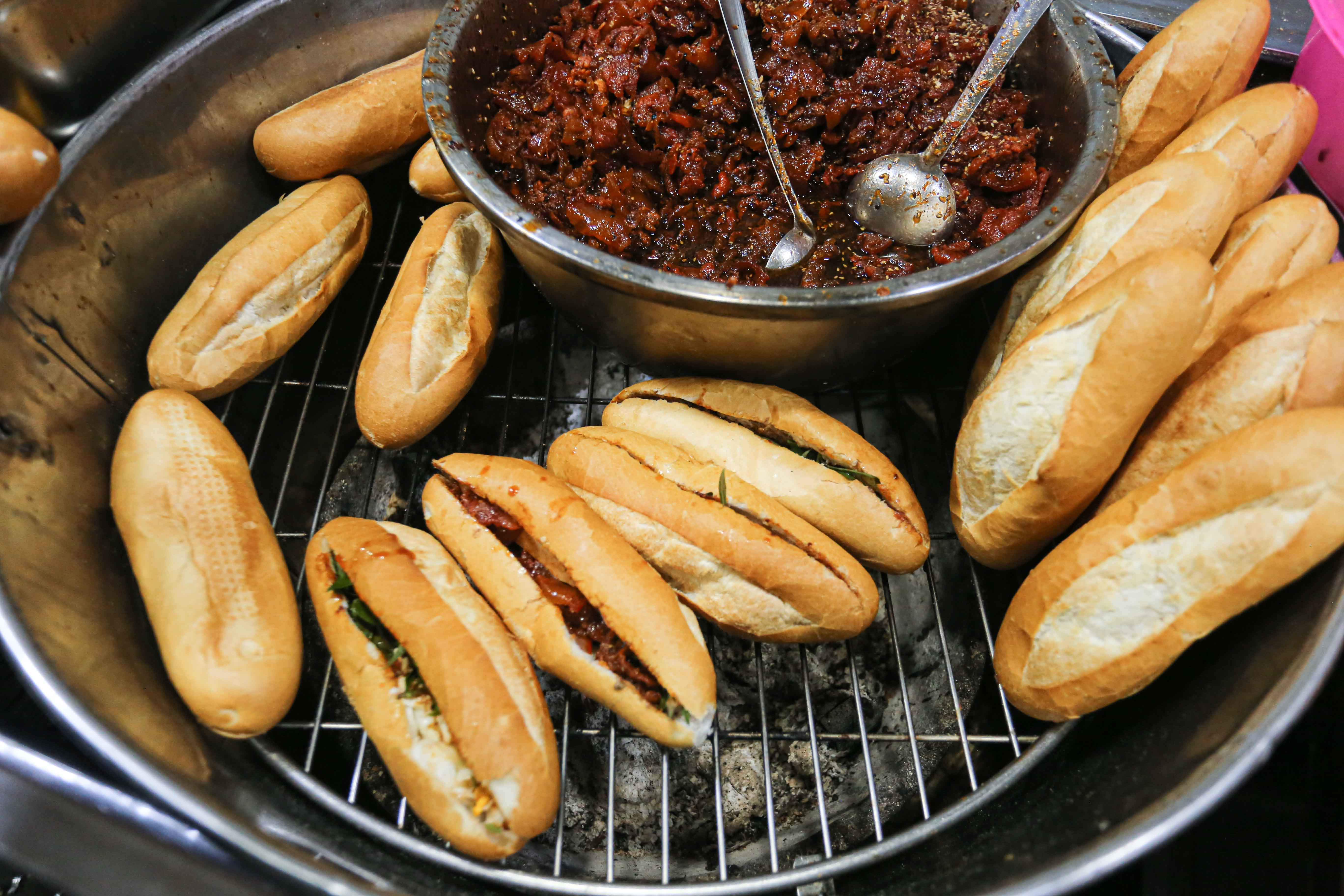 Những ổ bánh mì Trường Tiền giòn rụm được hơ nóng trên bếp than hồng, tạo hương vị đặc trưng