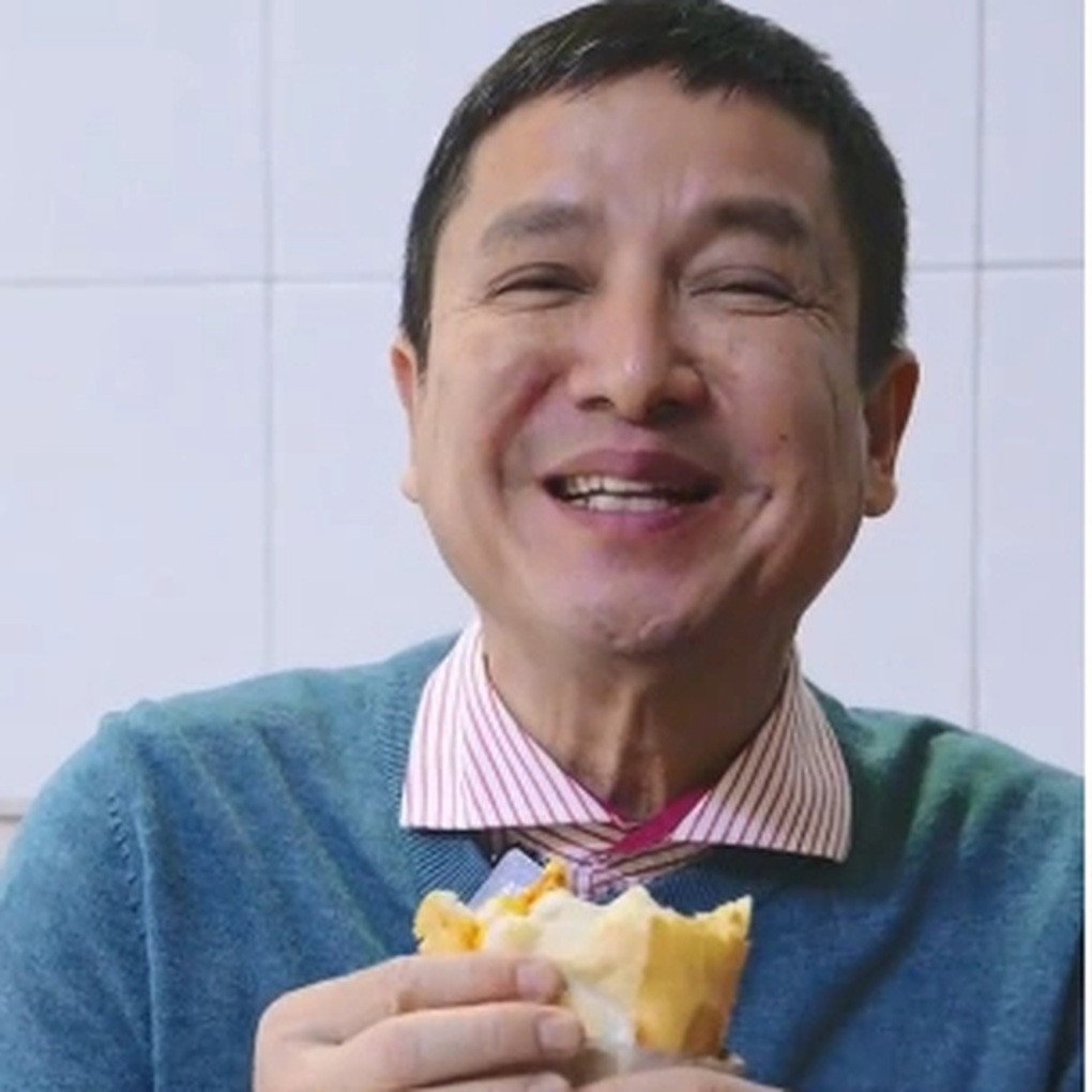 NSƯT Chí Trung thưởng thức bánh mì tại quán trên phố Huế, một khách hàng thân thiết từ lâu.