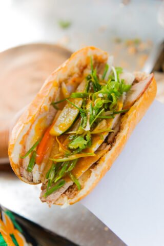 Ổ bánh mì Hồ Chí Minh đầy ắp nhân thịt, dưa chuột, hành lá và tương ớt