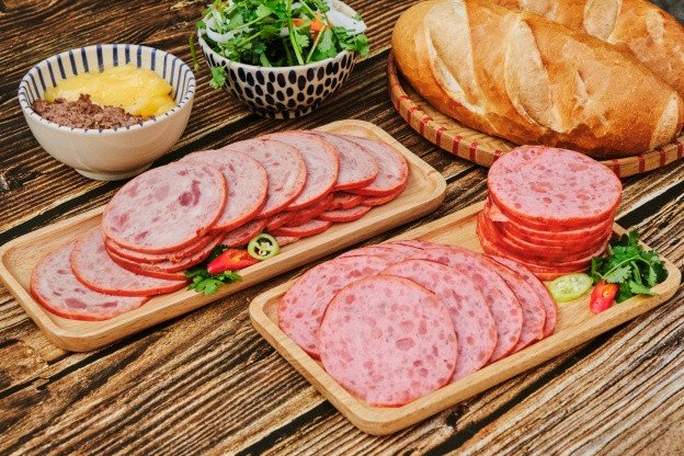 Ổ bánh mì Huynh Hoa đầy ắp nhân thịt nguội và rau thơm tươi ngon