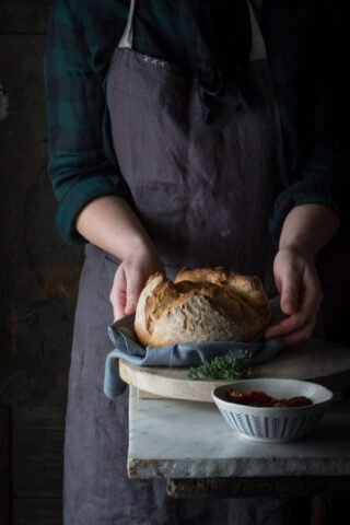 Ổ bánh mì sourdough nướng vàng ươm với vết cắt artístic, thể hiện vẻ đẹp tự nhiên và kỹ thuật làm bánh