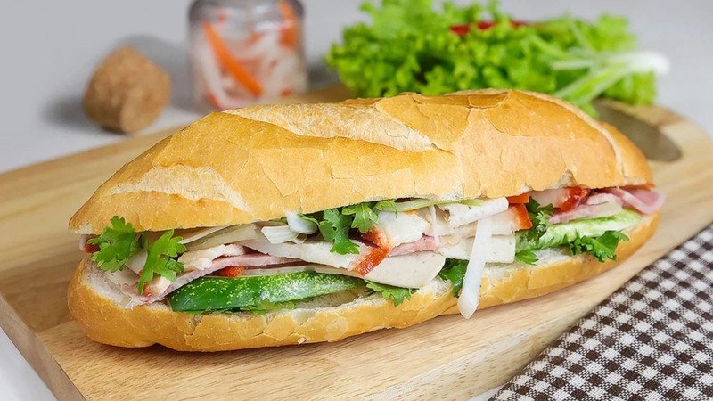 Ổ bánh mì thịt kiểu Việt Nam truyền thống đầy đủ topping, cho thấy sự đa dạng của nhân bánh mì