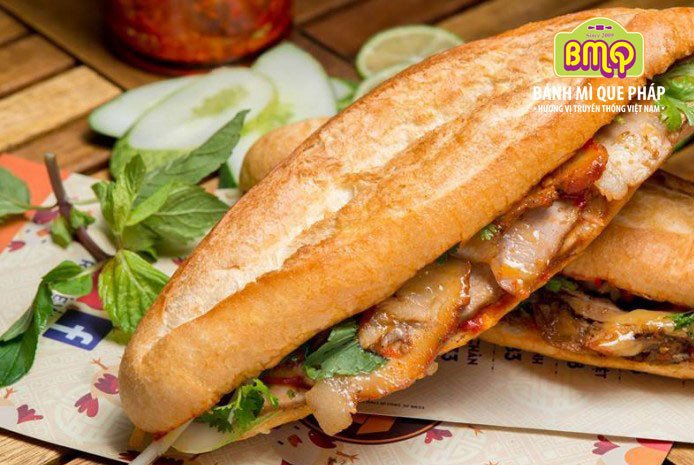 Ổ bánh mì thịt nướng thơm ngon, đầy ắp thịt, rau sống và dưa chua
