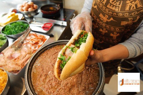 Ổ bánh mì Việt Nam kẹp pate ăn kèm dưa chuột và rau thơm, biểu tượng ẩm thực đường phố
