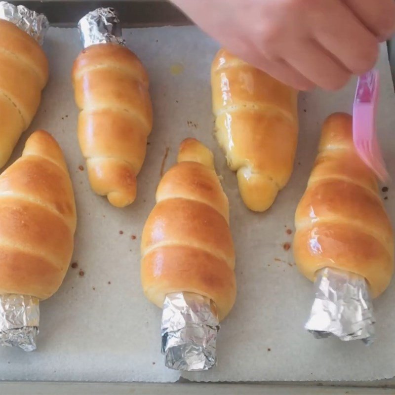 Phết bơ chảy lên bánh mì ốc quế vừa nướng xong