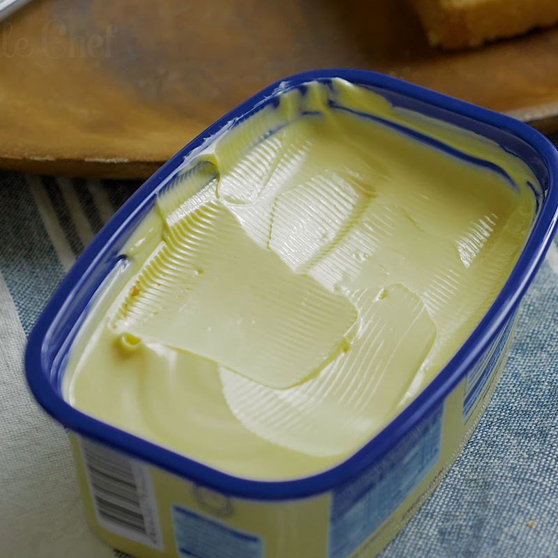 Phết bơ đều lên lát bánh mì chuẩn bị làm bánh mì kẹp phô mai