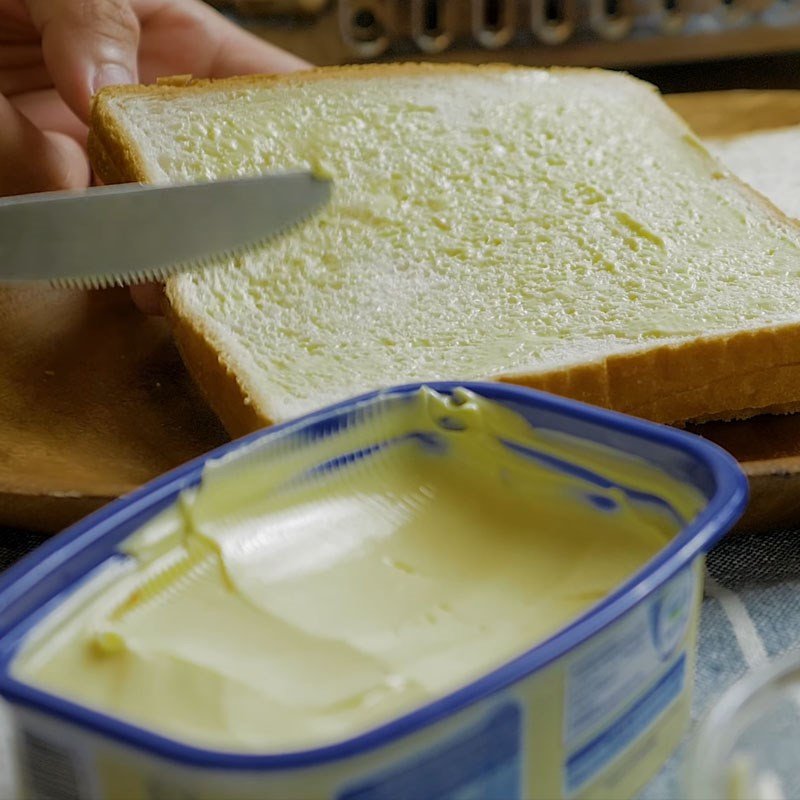 Phết bơ đều lên lát bánh mì sandwich để nướng