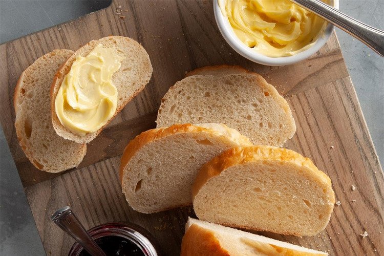 Phết bơ đều lên từng lát bánh mì để chuẩn bị nướng với nồi chiên không dầu