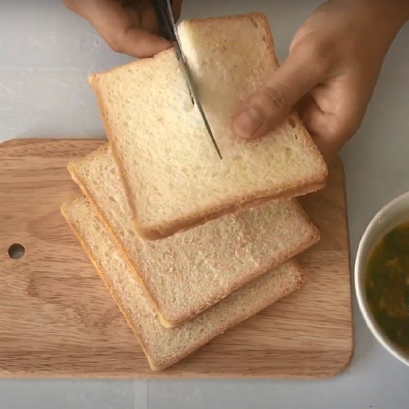 Phết đều sốt bơ tỏi lên lát bánh mì sandwich, chuẩn bị nướng bằng chảo chống dính