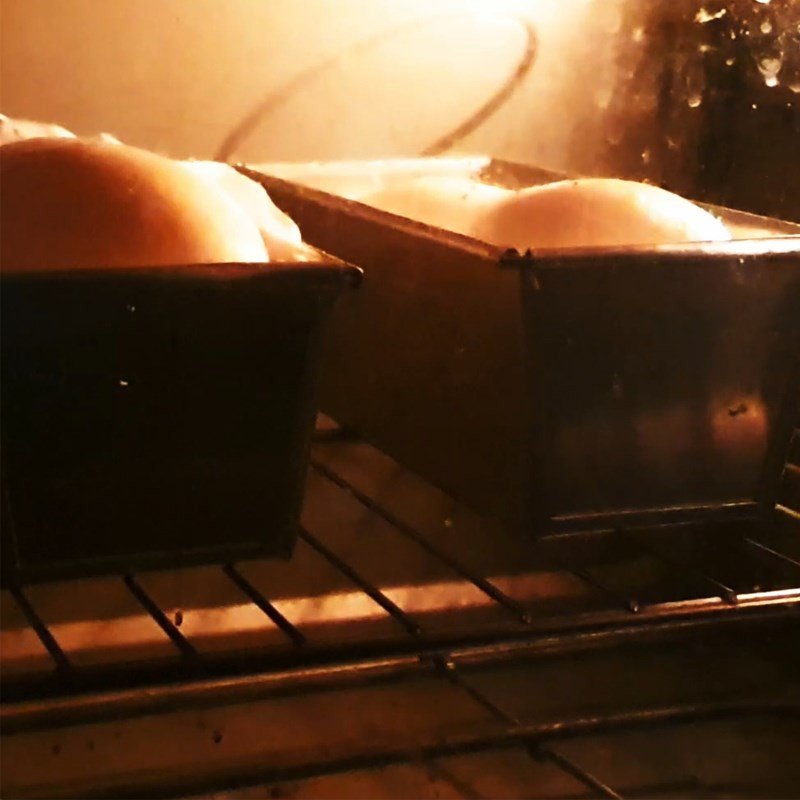 Phết hỗn hợp trứng và sữa lên mặt bánh mì trứng muối chà bông trước khi nướng