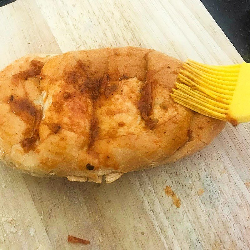 Phết sốt muối ớt cay lên bánh mì để nướng lò tạo nên bánh mì nướng muối ớt Đà Nẵng