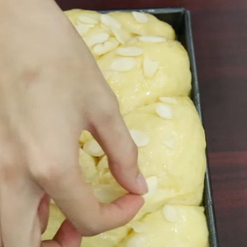 Phết trứng và rắc hạnh nhân lên mặt bánh mì hoa cúc