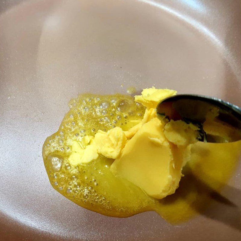 Phi tỏi vàng thơm với bơ trên chảo chống dính, bước quan trọng để có bánh mì bơ tỏi ngon