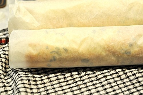 Quá trình cuộn chặt tấm bánh mì đã được phết nhân để tạo hình cho bánh mì cuộn trứng.