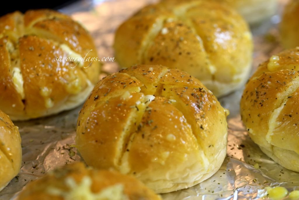 Rắc lá thơm và phết bơ tỏi lên bề mặt bánh mì trước khi nướng