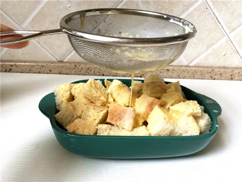 Rây hỗn hợp trứng sữa qua rây để loại bỏ cặn, đảm bảo món bánh mì trứng sữa từ bánh mì cũ mềm mượt