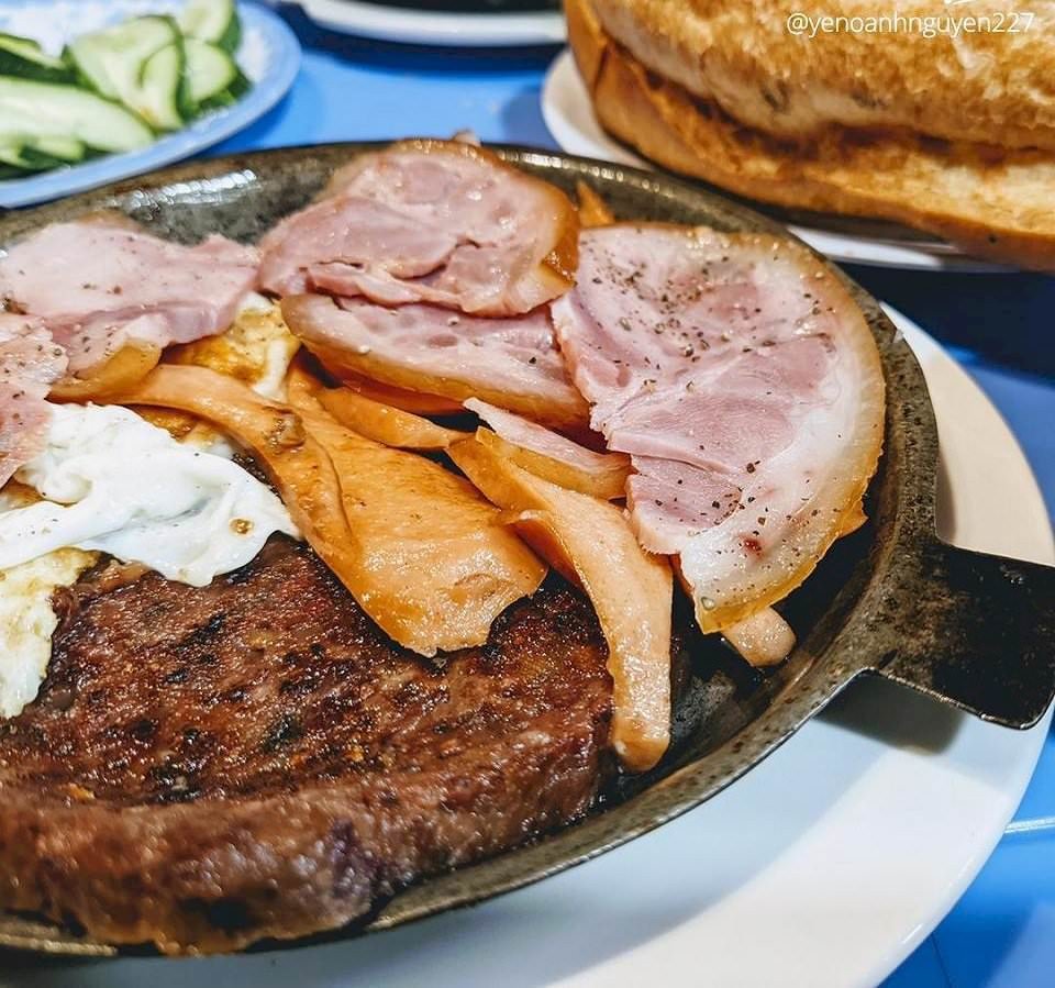 Suất bánh mì chảo truyền thống với pate, xúc xích và trứng ốp la vàng ươm, phục vụ tại quán ăn sáng nổi tiếng Hà Nội