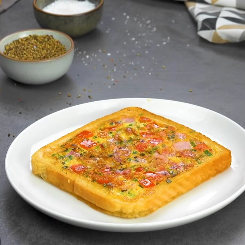 Thành phẩm pizza làm từ bánh mì với thịt nguội và trứng chiên