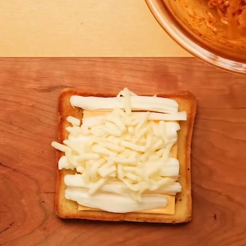 Thêm mì cay nóng hổi vào giữa lớp phô mai để tạo bánh mì kẹp phô mai mì cay