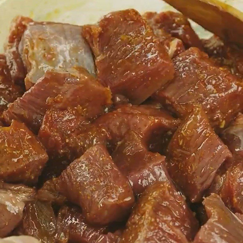 Thịt bò đang được ướp cùng bột cà ri và các gia vị đậm đà