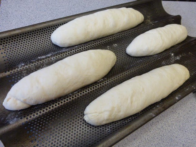 Thợ làm bánh rạch mặt bánh mì trước khi nướng