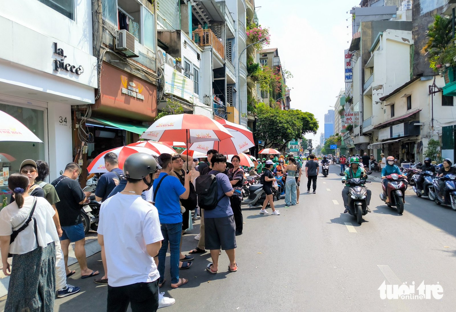 Thực khách cùng xe máy đứng chờ mua bánh mì Huỳnh Hoa ở vỉa hè phía đối diện, cho thấy mức độ thu hút của quán.