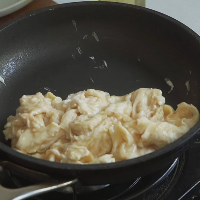 Trứng chiên trên chảo chống dính chuẩn bị làm bánh mì kẹp trứng