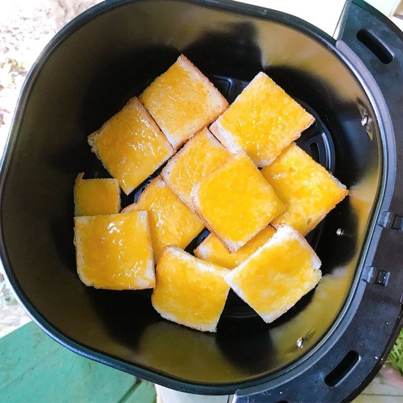 Xếp bánh mì đã quét trứng vào nồi chiên không dầu để nướng