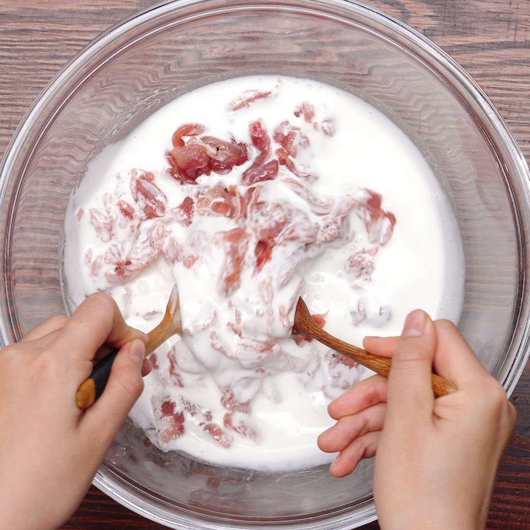 Áo đều bột khoai tây cho từng miếng thịt heo trước khi chiên xù