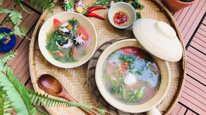 Bạch tuộc nhúng mẻ với nước dùng chua thanh và rau sống đa dạng.