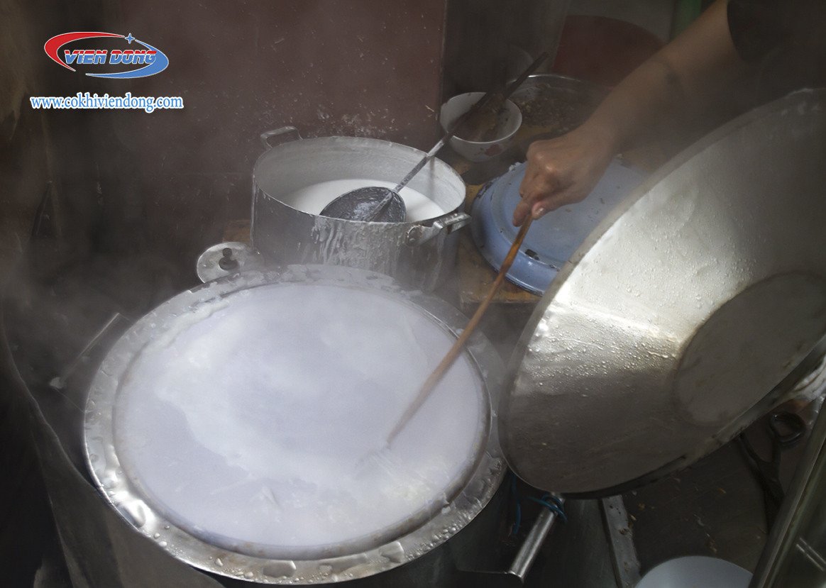 Bàn tay đang kiểm tra độ sánh mịn của bột bánh cuốn, quyết định chất lượng vỏ bánh.