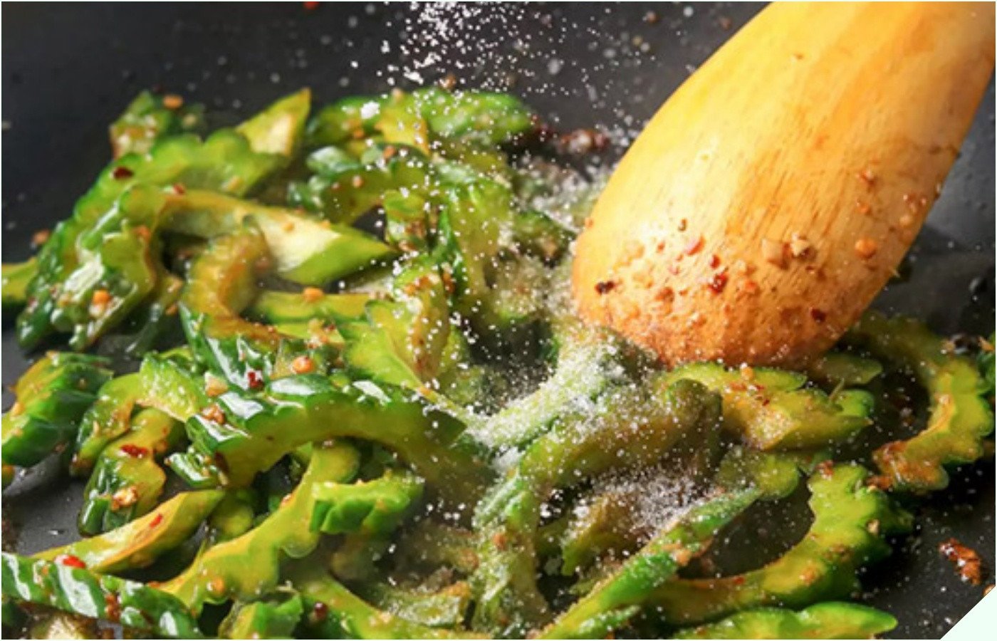 Bàn tay đang nêm gia vị vừa phải cho món khổ qua xào trứng