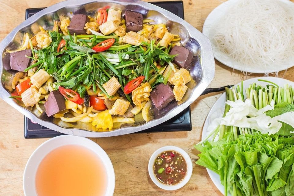 Bàn tiệc lẩu lòng bò nóng hổi với đa dạng rau và topping hấp dẫn