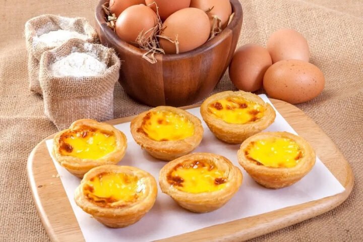 Bánh tart trứng vàng óng sau khi nướng bằng nồi chiên không dầu, đặt trên giá.