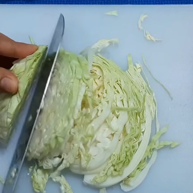 Bắp cải thái sợi mỏng, rửa sạch để chuẩn bị xào mì gói
